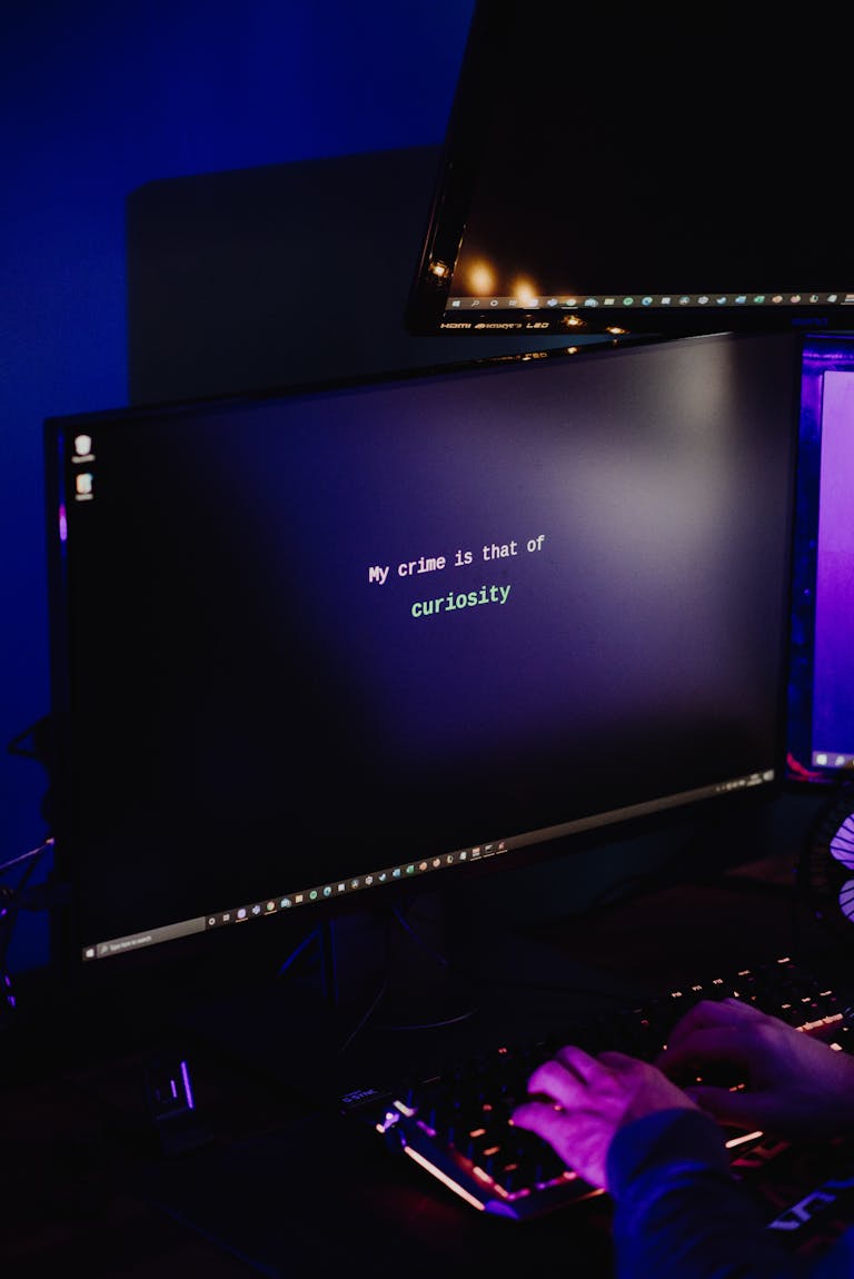 A hacker typing on a keyboard in a dimly lit room, highlighting cybersecurity threats at night.