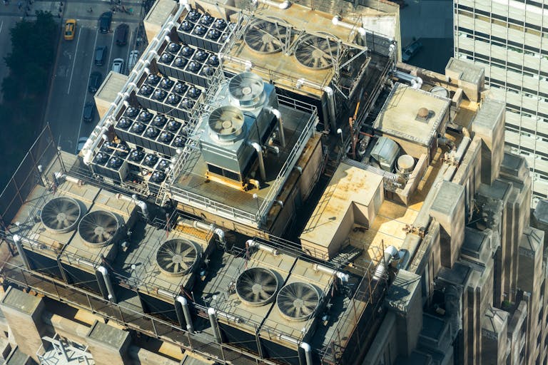 High-angle shot of HVAC units on a city building's rooftop, showcasing industrial infrastructure.