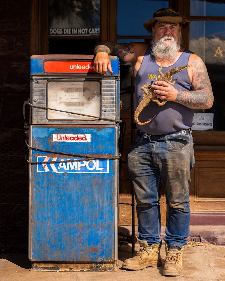 Rugged man in Australian outback with vintage Ampol petrol pump in Burra, South Australia.