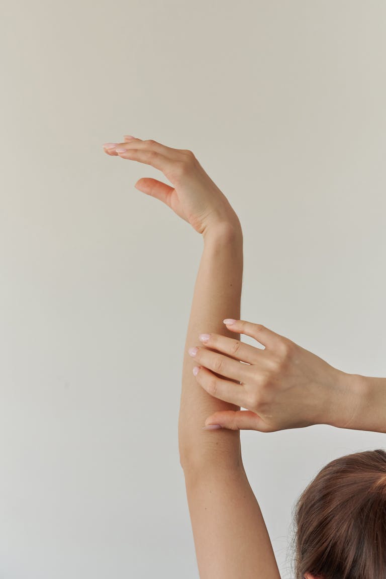 A serene composition featuring a woman's arm gracefully stretched against a neutral background.