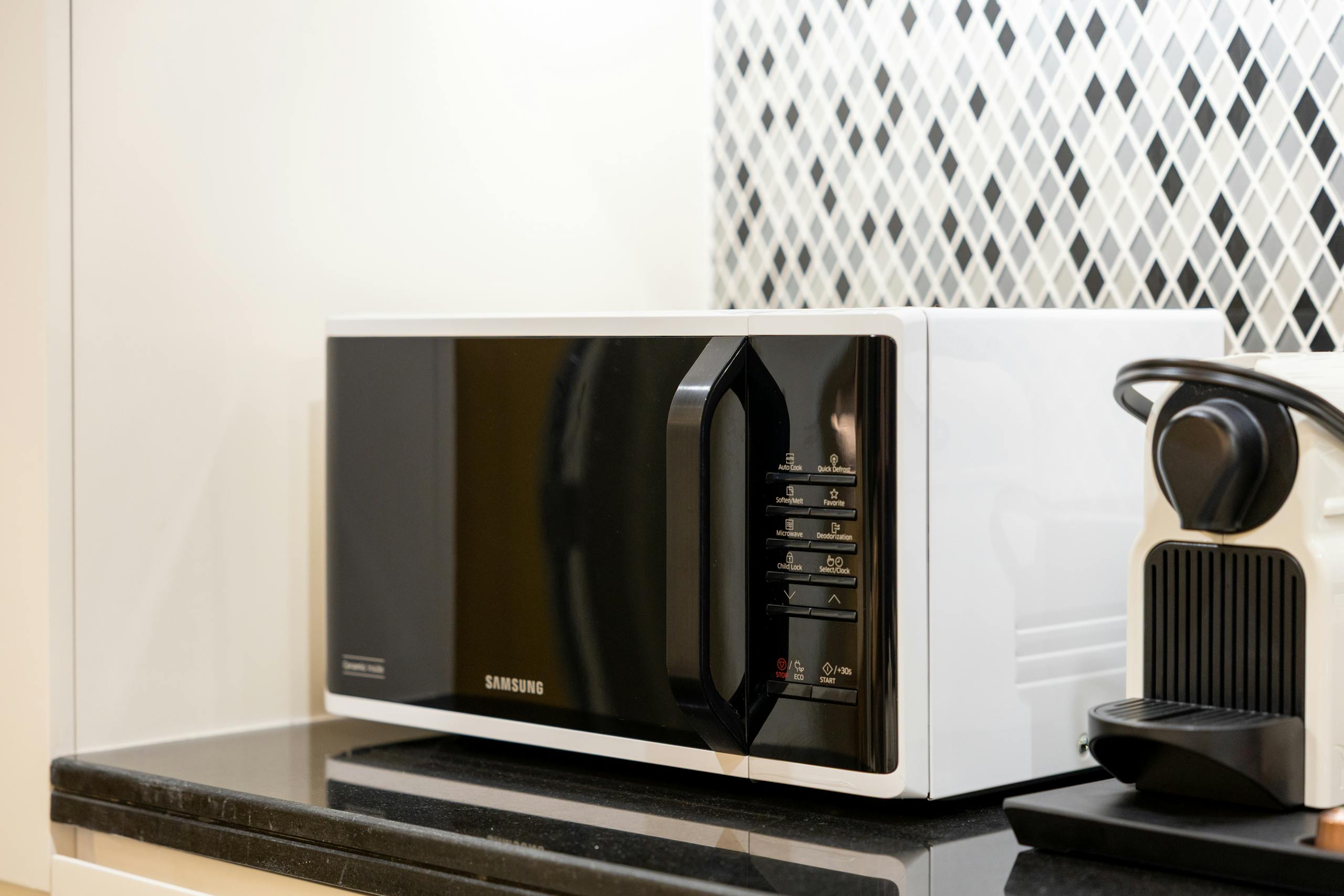 Stylish kitchen setup featuring a black microwave and coffee maker on a counter.