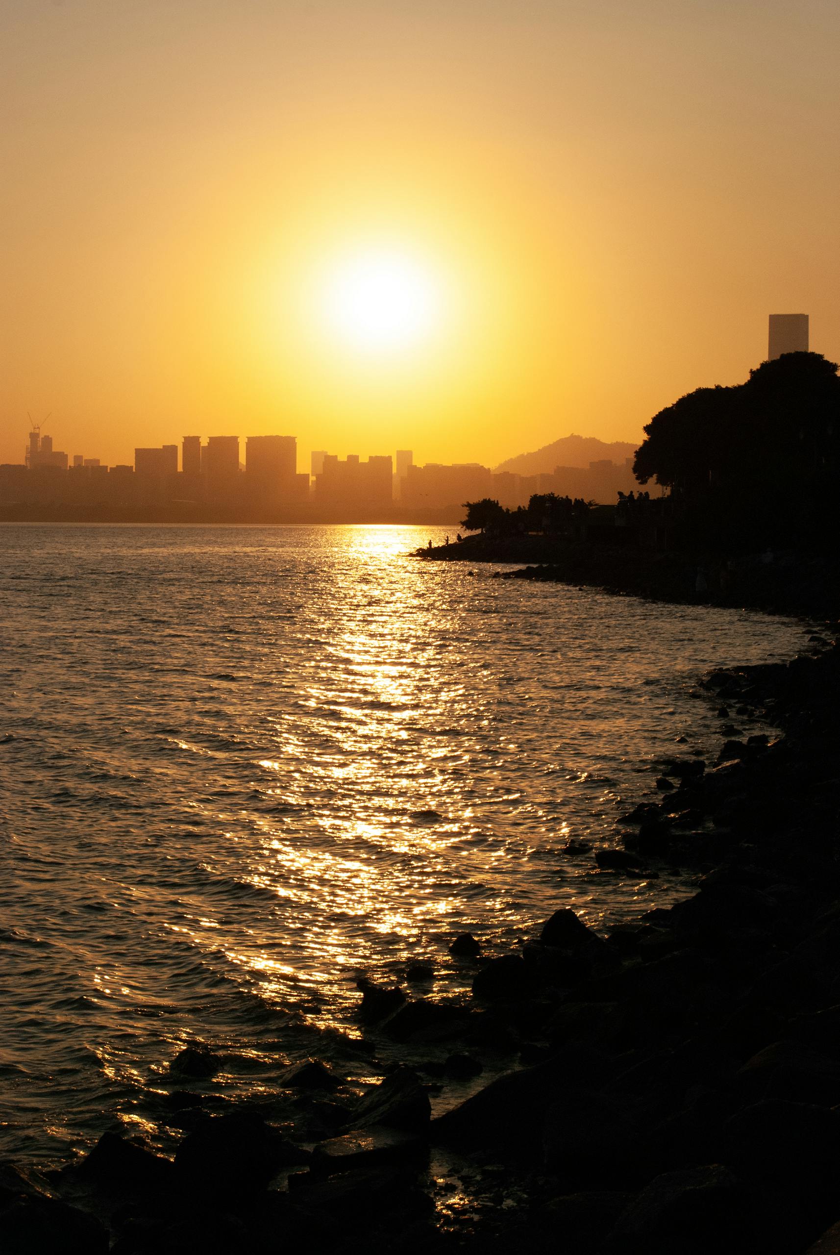 Beautiful sunset over the Shenzhen skyline with reflective waterfront, capturing the serene ambiance of the city.