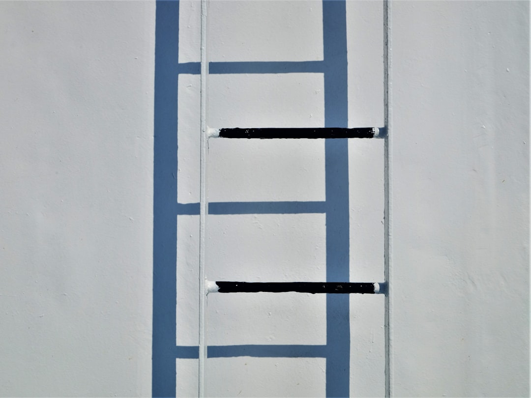 A ladder leaning up against a white wall