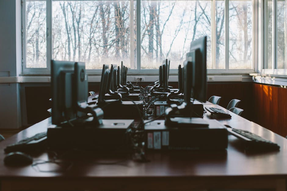 A controlled cybersecurity lab scene with computers and terminal screens to ground the discussion of benchmark testing.