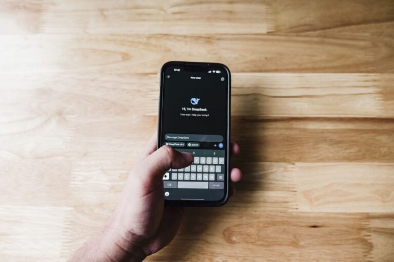 ai chatbots: Person using a chatbot app on a smartphone in a modern workspace.