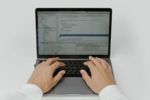 AI coding agent: Software engineer coding on a laptop in a modern workspace