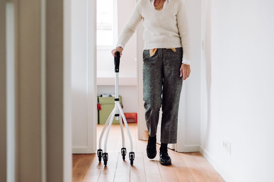 Frail older adult walking with support outdoors
