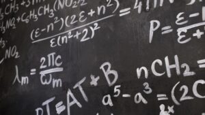 yuji tachikawa claude physics problem: A theoretical physicist writing equations on a blackboard