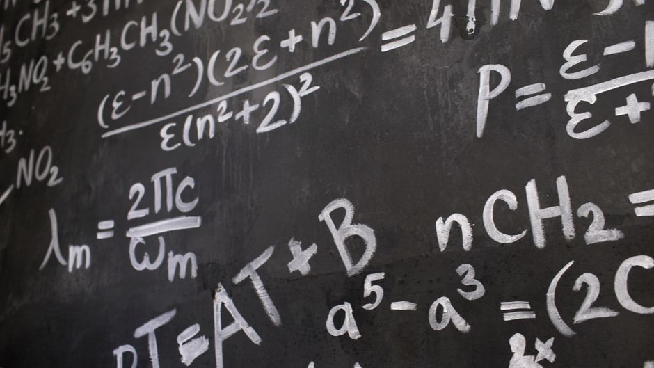 yuji tachikawa claude physics problem: A theoretical physicist writing equations on a blackboard