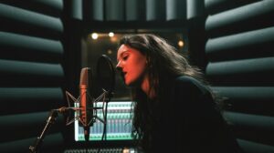 ai impersonation laws: Musician recording vocals in a professional recording studio.
