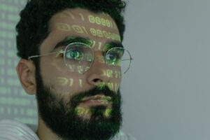 Security engineer reviewing source code and vulnerability alerts on multiple monitors