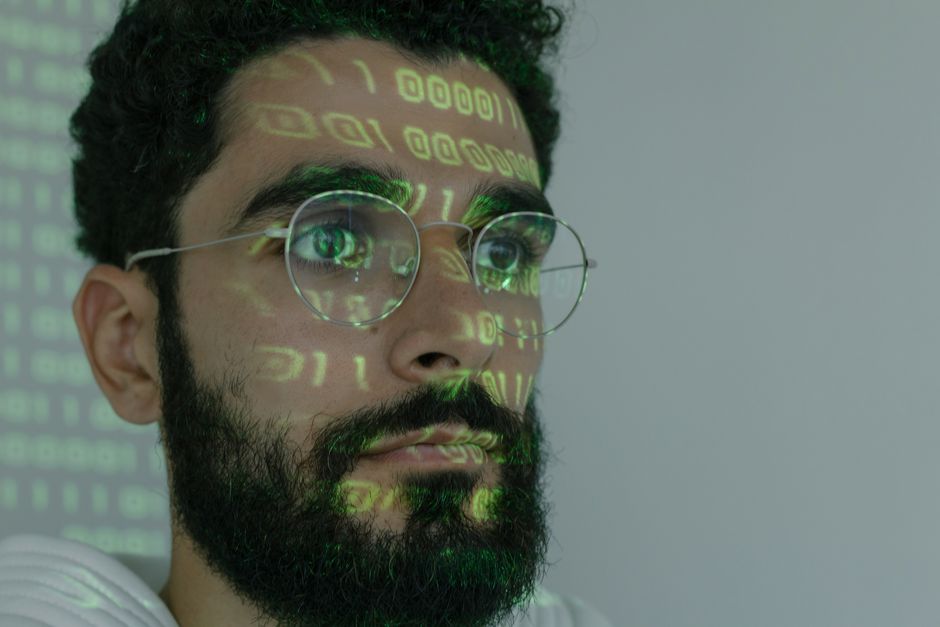 Security engineer reviewing source code and vulnerability alerts on multiple monitors