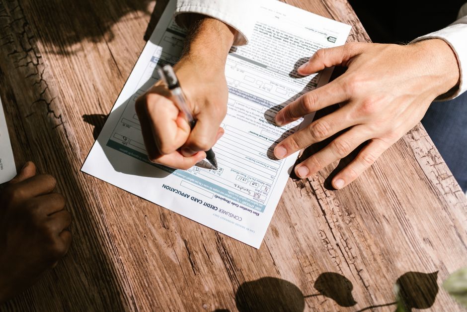 Close-up of consumer credit report documents and financial paperwork on a desk, representing the files used to build a consumer profile.